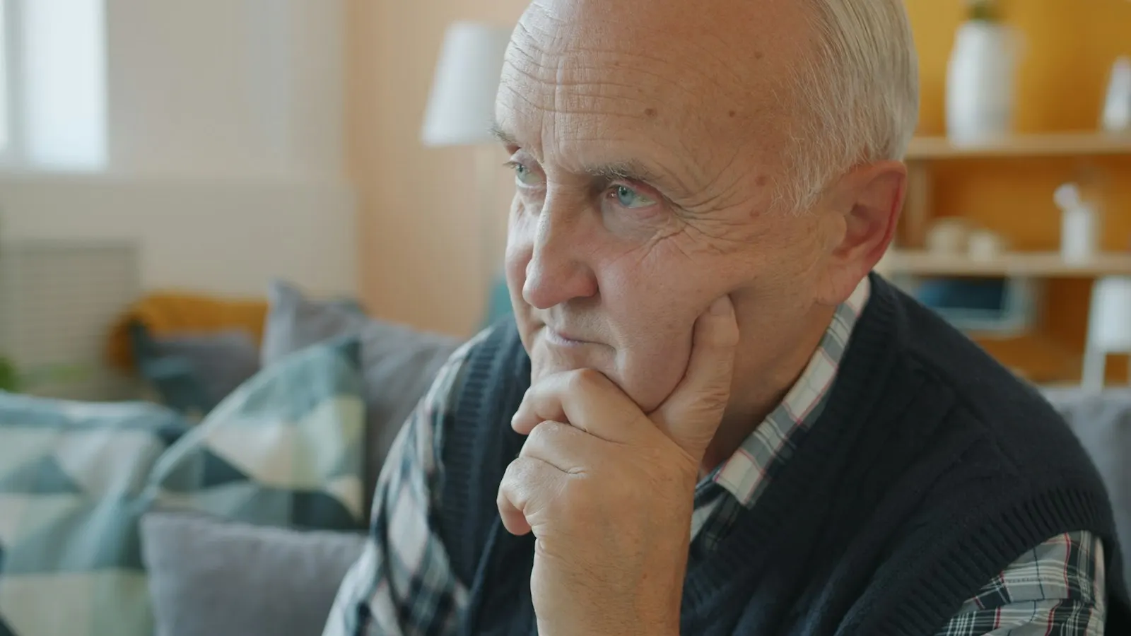 An older man with his hand on his chin, deep in thought