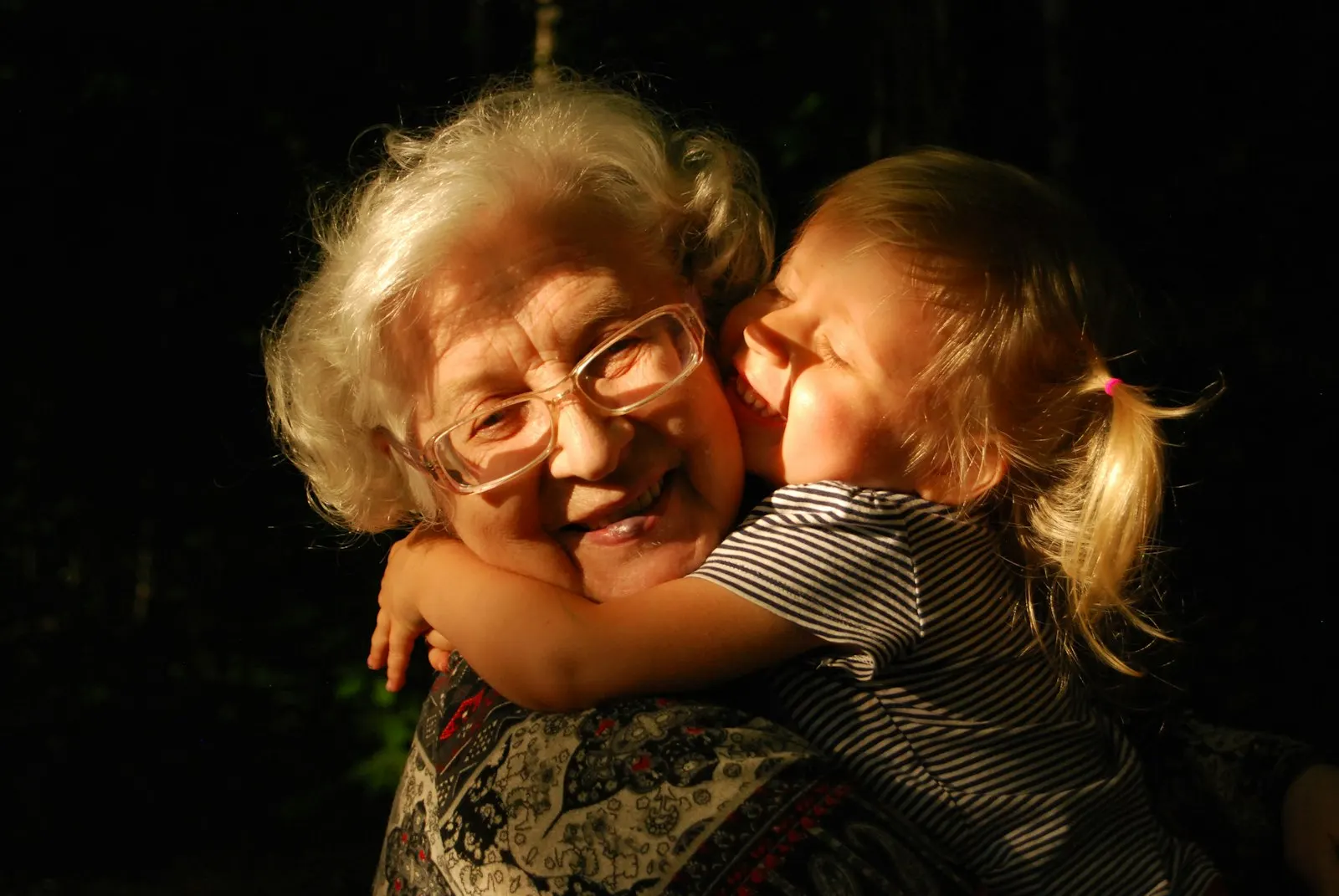 An older woman hugging a young child