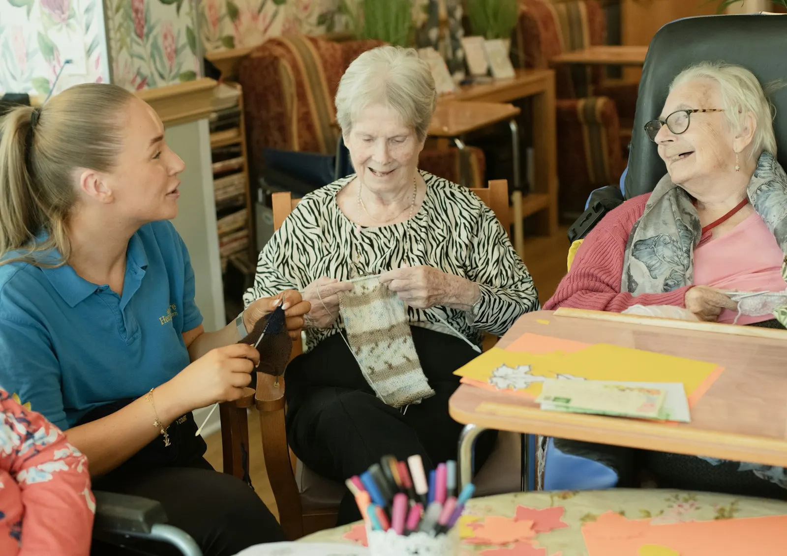 A carer knitting with two older women