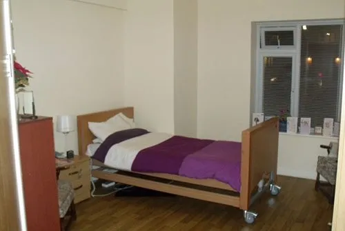 A bedroom with a profiling bed, wardrobe and window, photographed when the home opened