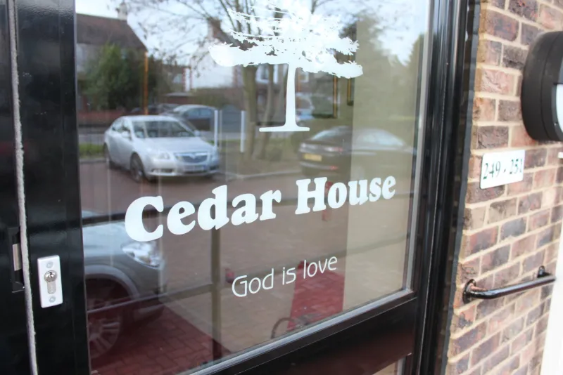 The front door with Cedar House and God is love on the glass