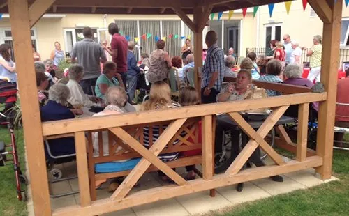 Residents and families at a garden party under the pagoda